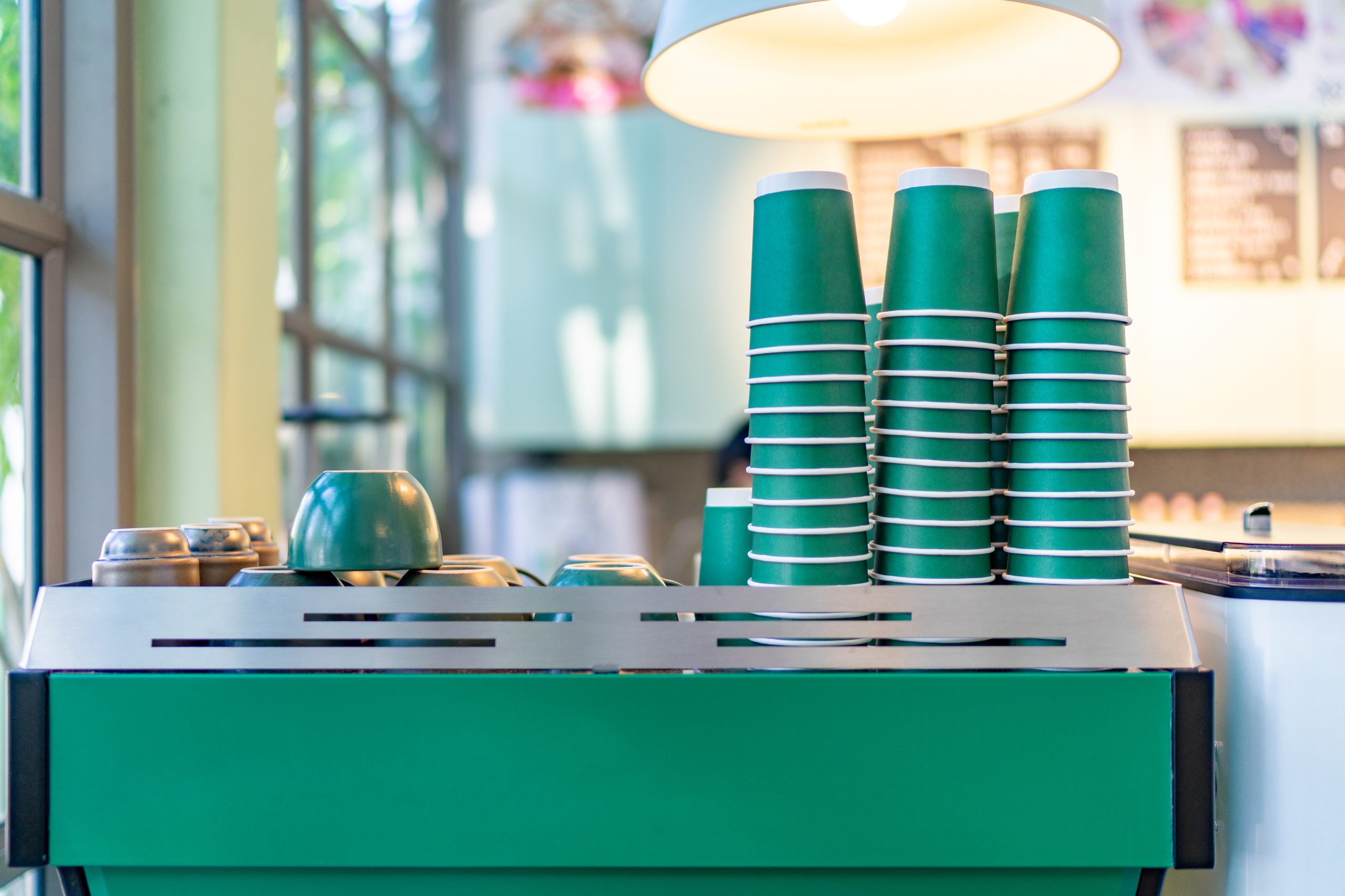 Paper coffee cup and ceramic coffee cup on counter